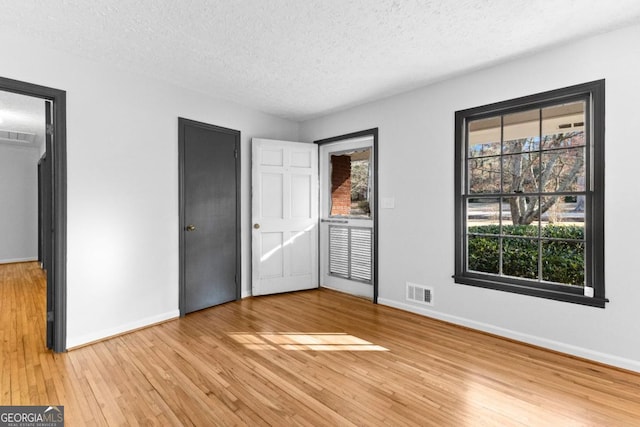 unfurnished bedroom featuring wood-type flooring and a textured ceiling