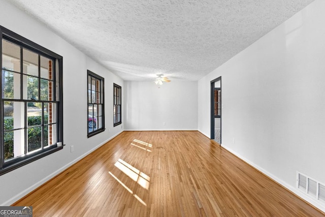 spare room with hardwood / wood-style floors and a textured ceiling