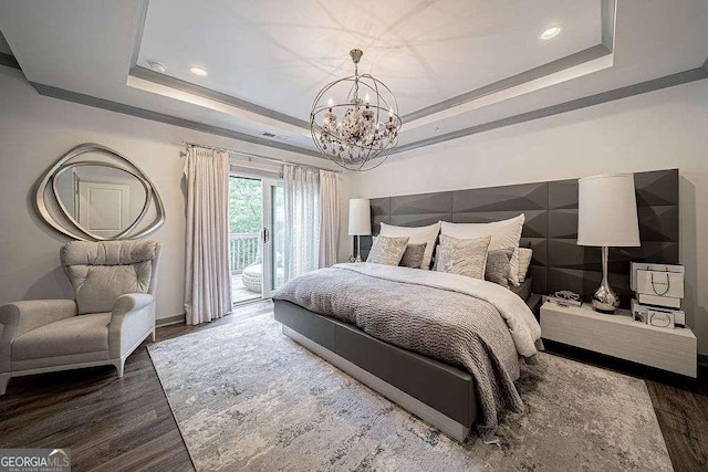 bedroom featuring wood-type flooring, a tray ceiling, access to exterior, and a notable chandelier