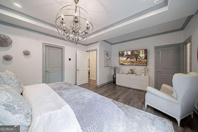 bedroom with dark wood-type flooring, ornamental molding, a raised ceiling, and a chandelier