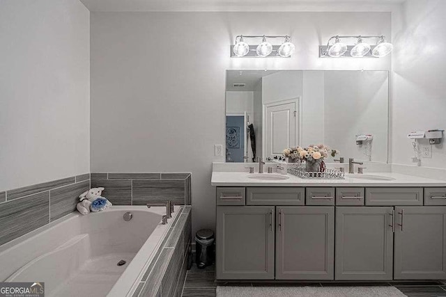 bathroom featuring vanity and tiled tub