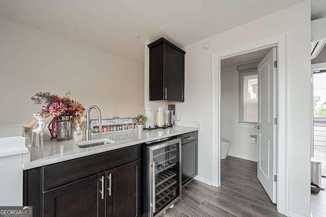 kitchen featuring wine cooler, dark brown cabinetry, sink, and hardwood / wood-style floors