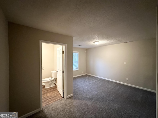 carpeted spare room with a textured ceiling