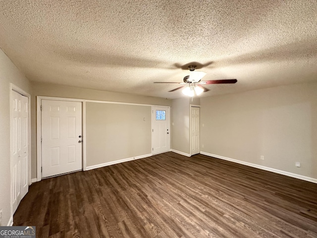 empty room featuring a textured ceiling, dark wood-type flooring, and ceiling fan