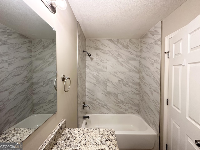 bathroom featuring vanity, tiled shower / bath combo, and a textured ceiling