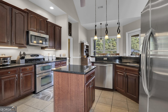 kitchen featuring hanging light fixtures, light tile patterned flooring, stainless steel appliances, and a kitchen island