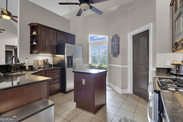 kitchen featuring appliances with stainless steel finishes, a center island, sink, and light tile patterned floors