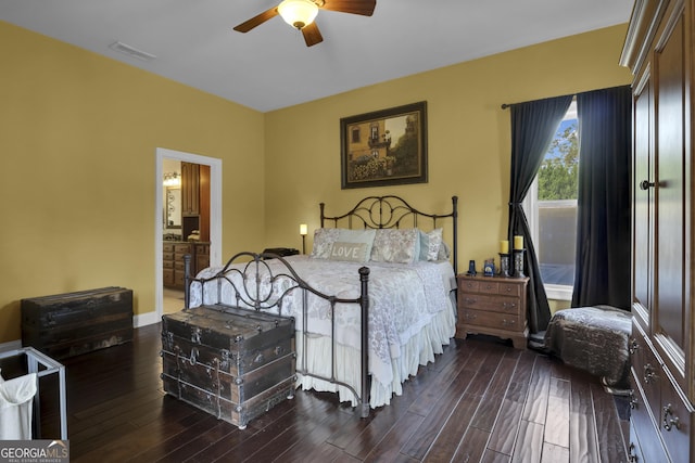 bedroom with dark wood-type flooring, ceiling fan, and connected bathroom