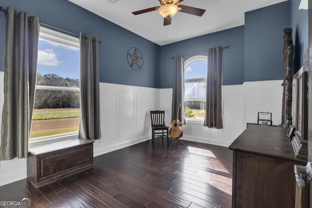 sitting room featuring dark wood-type flooring and ceiling fan