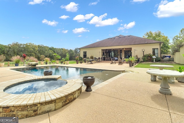 view of swimming pool featuring an in ground hot tub and a patio