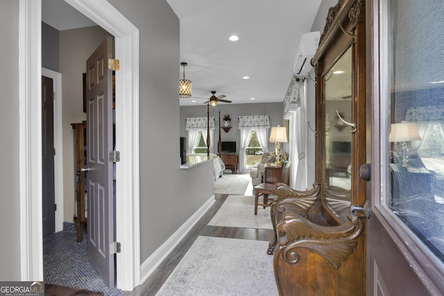 hall with a wall mounted AC and dark hardwood / wood-style flooring