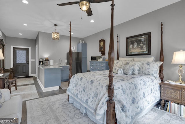 bedroom with sink, dark wood-type flooring, and stainless steel refrigerator