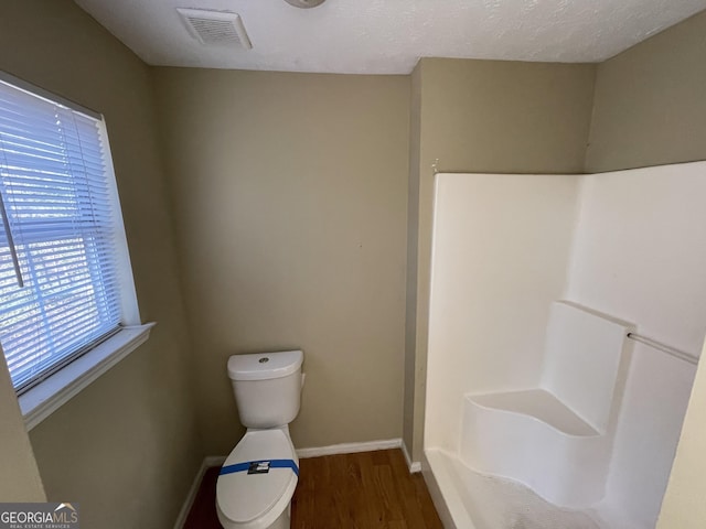 bathroom with hardwood / wood-style floors and a textured ceiling