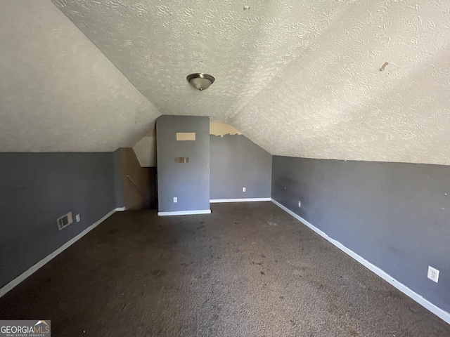 bonus room featuring vaulted ceiling, carpet, and a textured ceiling