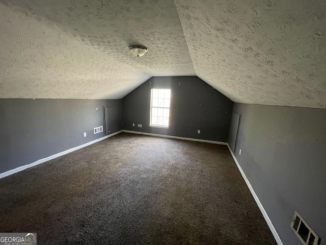 bonus room with carpet floors, a textured ceiling, and vaulted ceiling