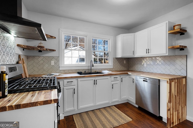 kitchen featuring white cabinetry, butcher block countertops, ventilation hood, and appliances with stainless steel finishes