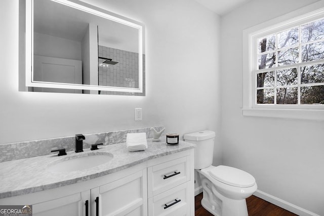 bathroom featuring walk in shower, vanity, toilet, and hardwood / wood-style floors