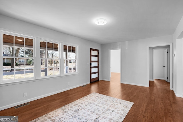 foyer entrance with a healthy amount of sunlight and dark wood-type flooring