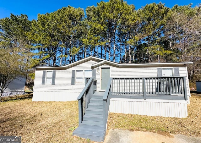 manufactured / mobile home with a front lawn and a deck