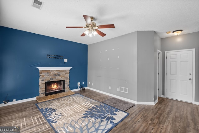 living room with hardwood / wood-style floors, a textured ceiling, and a fireplace