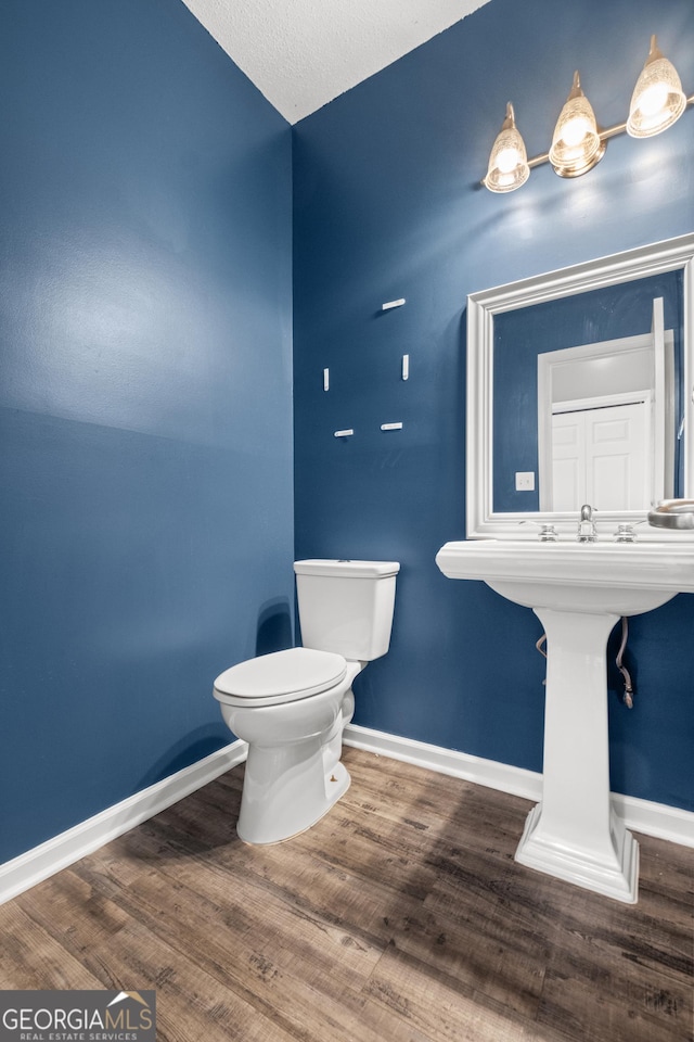 bathroom with hardwood / wood-style floors and toilet