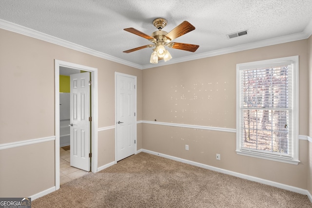 unfurnished bedroom featuring multiple windows, ornamental molding, light carpet, and a textured ceiling