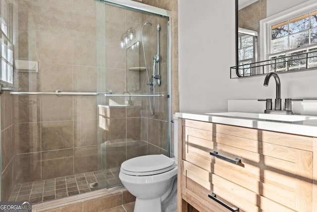 bathroom featuring walk in shower, vanity, and toilet