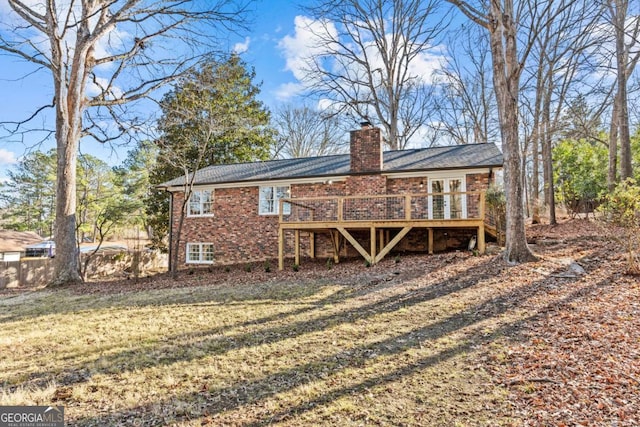 rear view of house featuring a yard and a deck