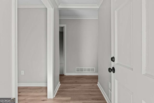 interior space with crown molding and light wood-type flooring