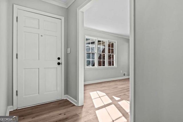 entrance foyer with crown molding and light hardwood / wood-style floors