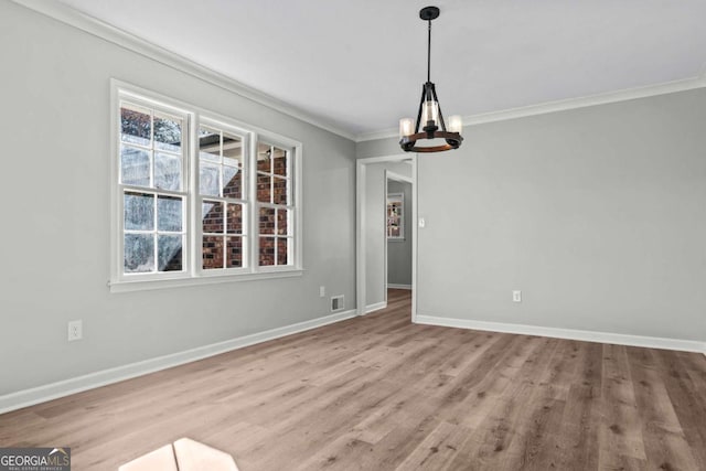 unfurnished dining area with an inviting chandelier, ornamental molding, light hardwood / wood-style flooring, and a wealth of natural light