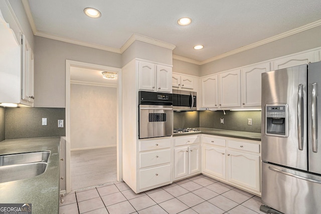 kitchen with light tile patterned flooring, crown molding, appliances with stainless steel finishes, white cabinets, and backsplash