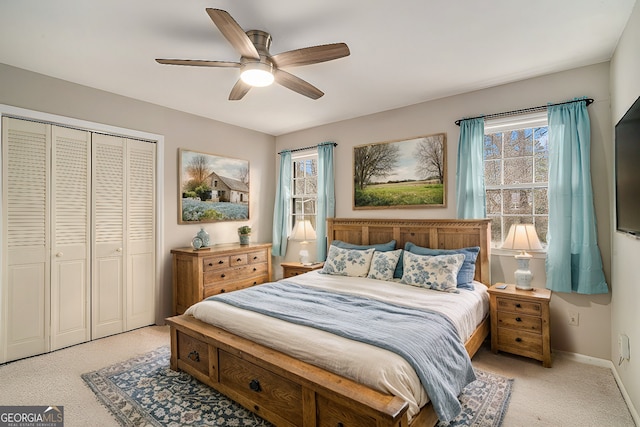 bedroom with light colored carpet, ceiling fan, and a closet