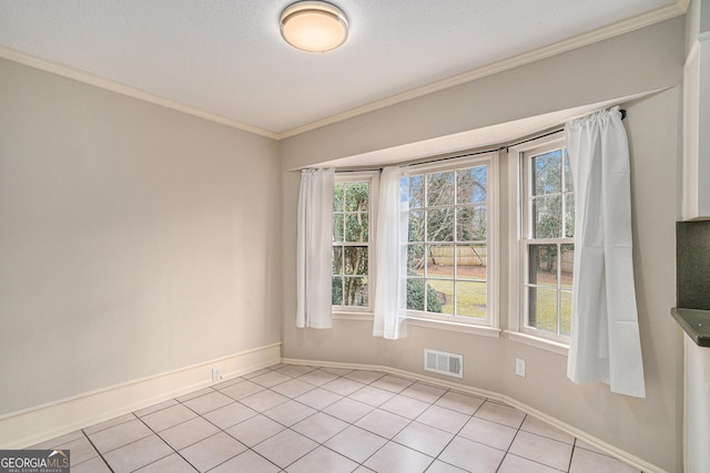 tiled empty room with crown molding and a textured ceiling