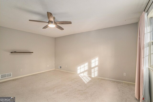 unfurnished bedroom featuring ceiling fan, light carpet, a textured ceiling, and a closet