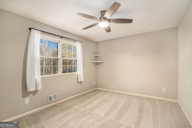 carpeted spare room featuring ceiling fan and a textured ceiling