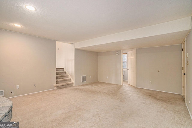 basement with light carpet and a textured ceiling