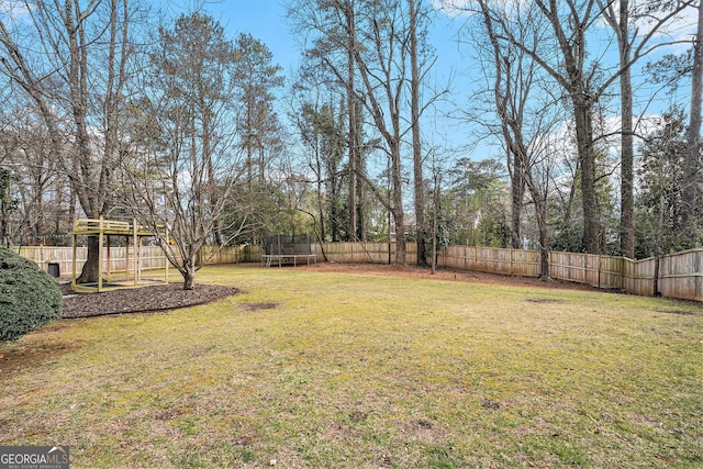 view of yard featuring a playground and a trampoline