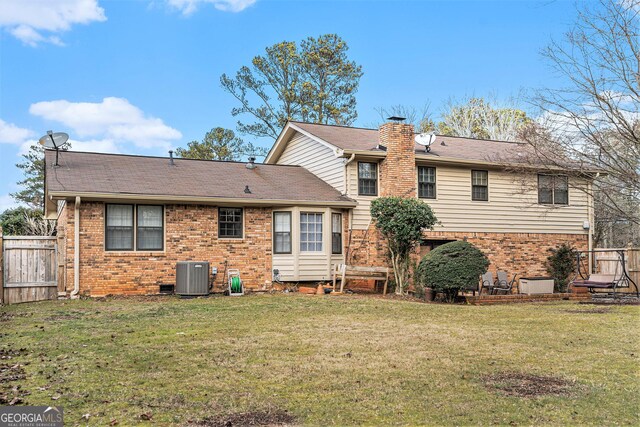 rear view of house with a yard and central AC