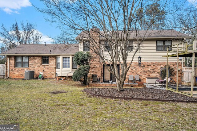 rear view of property with central AC unit, a yard, and a patio area