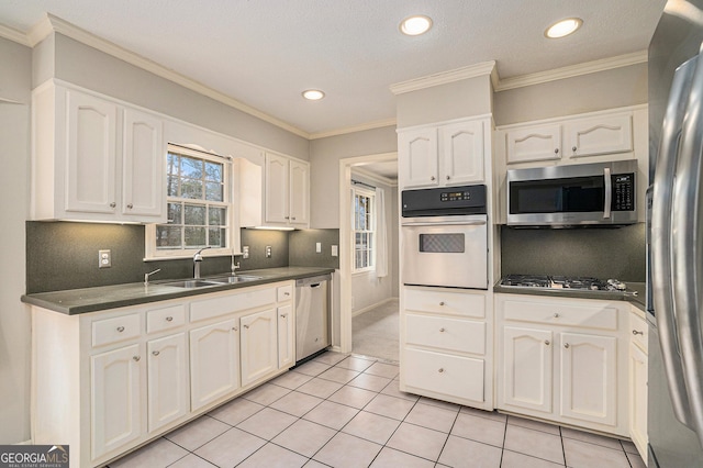 kitchen with tasteful backsplash, white cabinetry, appliances with stainless steel finishes, and sink