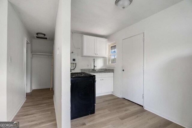 kitchen with white cabinetry, sink, light wood-type flooring, and black range with gas cooktop