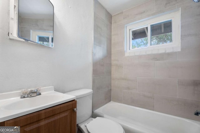 full bathroom featuring vanity, tiled shower / bath combo, and toilet