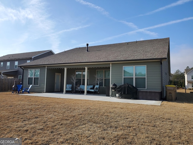 rear view of property featuring a patio and a lawn