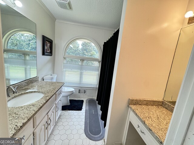 bathroom featuring crown molding, vanity, tile patterned flooring, and a textured ceiling
