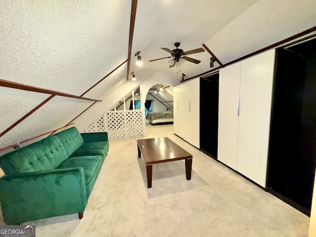 unfurnished living room featuring lofted ceiling, a textured ceiling, and ceiling fan