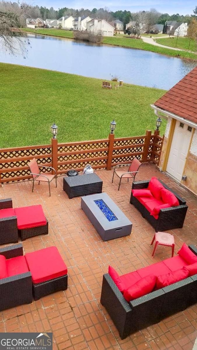 view of patio / terrace featuring a water view and an outdoor living space with a fire pit