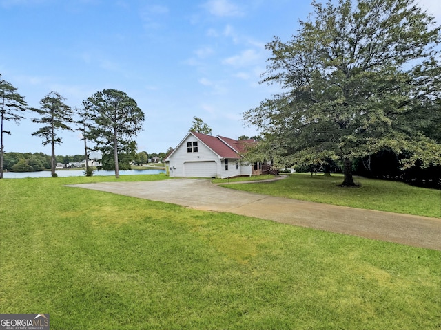 view of front of property with a water view, a garage, and a front lawn