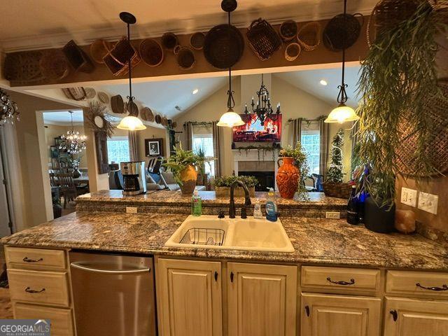 kitchen with crown molding, stainless steel appliances, cream cabinets, decorative light fixtures, and light wood-type flooring