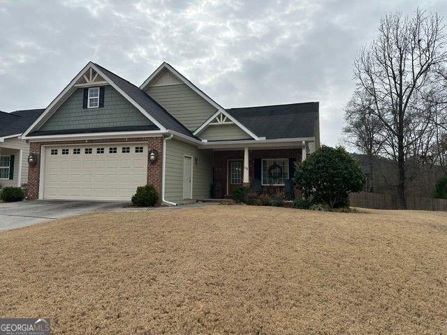 craftsman house with a porch, a garage, and a front yard